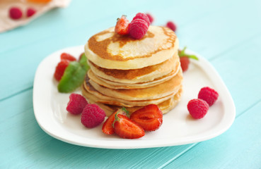 Tasty pancakes with berries on plate