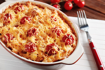Delicious pasta Al Forno in ceramic bowl on wooden table