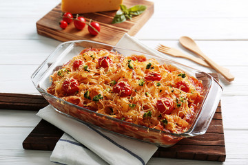Delicious pasta Al Forno in glass bowl on wooden table