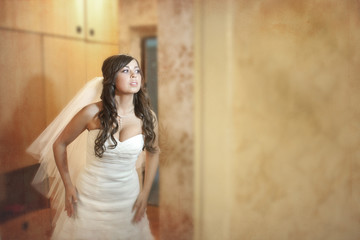 Fototapeta premium Bride bends ahead while posing in the room