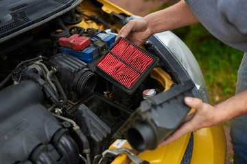 Service of old used car. Man fix car air filter.