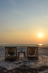 Two deckchair on the beach during sunset, Thailand