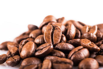 Brown roasted coffee beans close up on white background