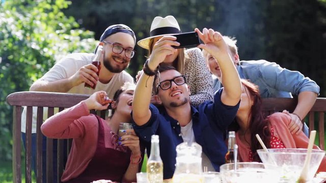 friends taking selfie at party in summer garden