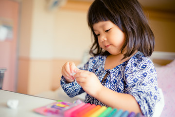 children's creativity. child sculpts from clay.Cute little girl moulds from plasticine on table