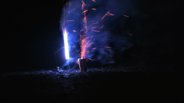 A set of "piccolo pete" firecrackers, ignite and shoot flames and sparks on the ground. HD 1080p.