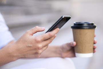 Close up of a businesswoman using mobile phone and holding paper