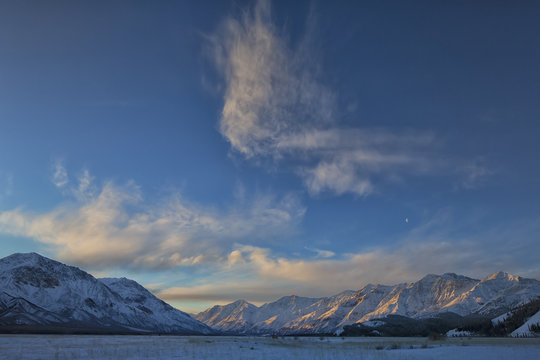 Dawn lights the sky over the Slims River Valley which is situated in Kluane National Park, Yukon. The moon can be seen near the middle of the frame.