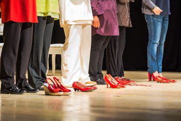 Scarpe rosse su un palco, simbolo della violenza sulle donne