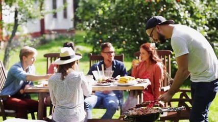 friends having barbecue party at summer garden - Powered by Adobe