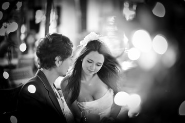 Spots of light shine around lovely wedding couple sitting on the