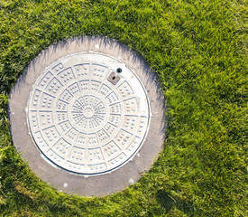 Closeup of a manhole and green grass