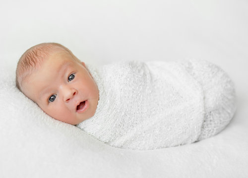 funny swaddled baby with open mouth