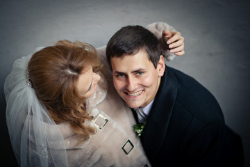 Handsome groom smiles broad while bride strokes his head