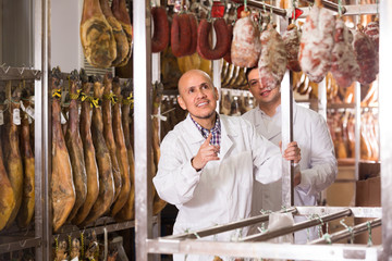 Technologist with butcher checking  wurst