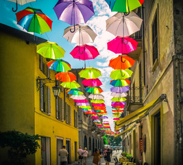 Fototapeta na wymiar Colourful umbrellas above a pedestrian street in Italy