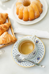 Taza de té con un bizcocho y croissant. Vista superior