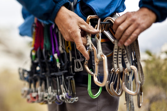Close up of man adjusting climbing carabiners