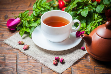 Healthy tea with a dogrose on wooden table