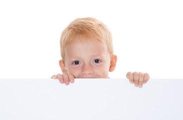Young boy behind white wall