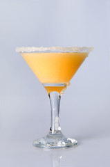 Martini glass  with orange juice close-up, decoration on the edge of a white crumb