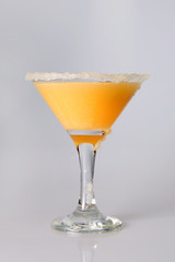 Martini glass  with orange juice close-up, decoration on the edge of a white crumb
