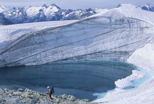 Rock climber, Tim Otke, climbing along the Asulkan Ridge traverse near a small glacial tarn below the summit of Mount Jupiter, Rogers Pass, Glacier National Park, British Columbia, Canada