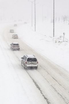 Traffic on a snow covered road, during a winter snowstorm.  Winnipeg, Manitoba, Canada.
