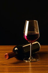 Red wine bottle with glass on black background - silhouette