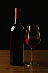 Red wine bottle with glass on black background - silhouette