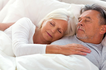 Senior couple sleeping in bed
