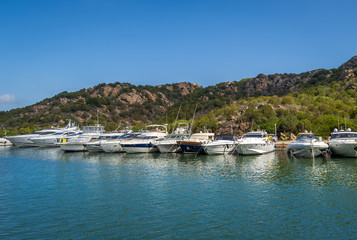 Fototapeta na wymiar Long pier with recreational fleet boats. Poltu Quatu resort marina, Sardinia.