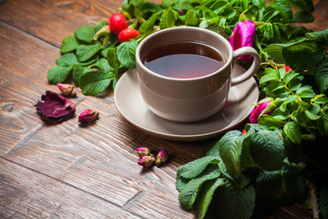 Healthy tea with a dogrose on wooden table