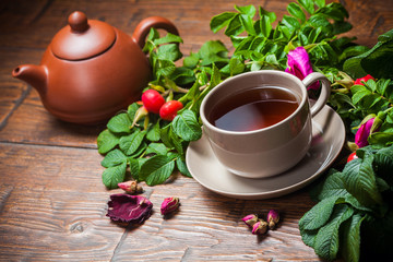 Healthy tea with a dogrose on wooden table