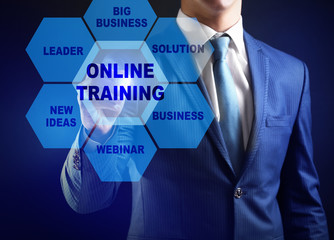 Businessman pushing ONLINE TRAINING button on virtual screen. Business coaching and modern technology concept.