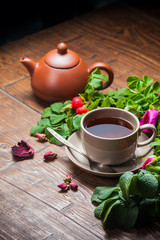 Healthy tea with a dogrose on wooden table