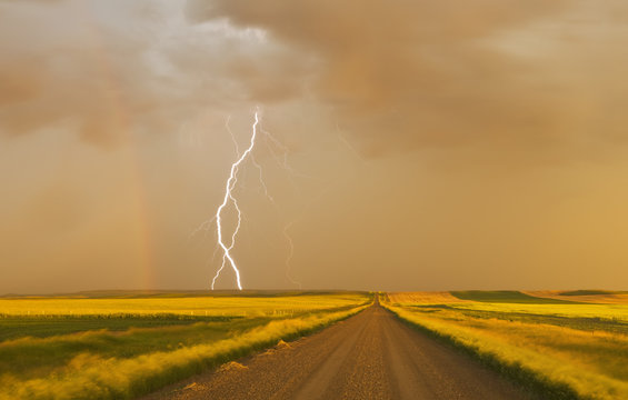 Lightening and rainbow on sky above field, Canada