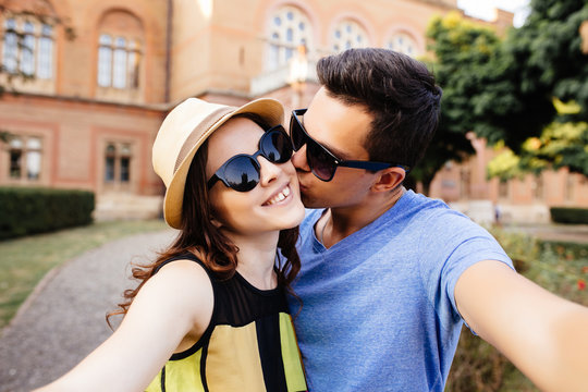Happy smiling couple kissing and taking selfie