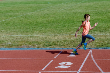 Fototapeta premium Kids sport, child running on stadium track, training and fitness concept 
