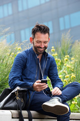 Obraz premium Smiling mature man listening to music on mobile phone