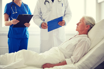 doctor and nurse visiting senior woman at hospital