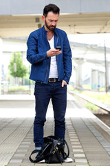 Man using mobile phone at train station