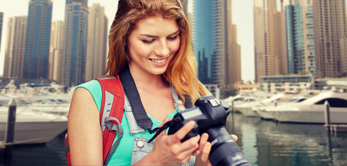 woman with backpack and camera over dubai city