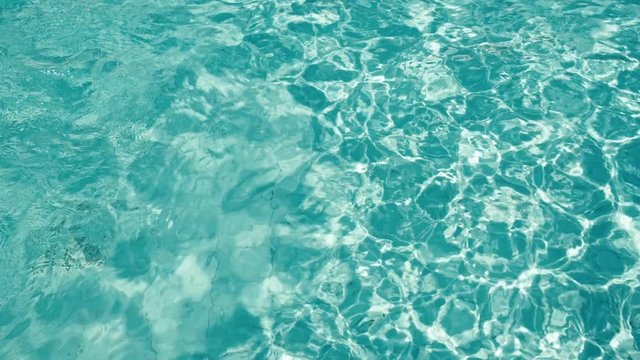 Blue water rippled background in swimming pool. 4K.