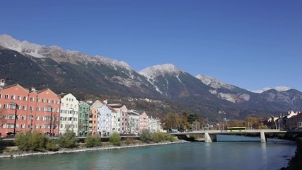 Colored houses by the Inn river with the mountains in the background at Mariahilfstrasse in Innsbruck, Austria