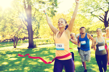 happy young female runner winning on race finish