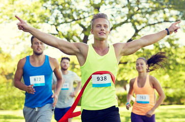 happy young male runner winning on race finish