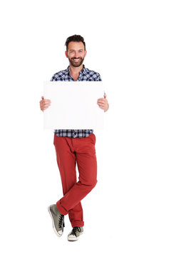 Handsome man holding blank poster over white background