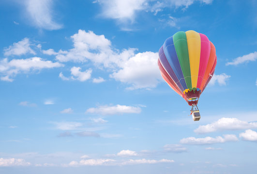 Hot air baloon with clouds blue sky background