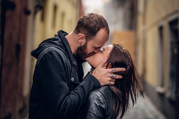 Fototapeta premium Pozytywny brodaty mężczyzna całuje śliczną brunetkę.